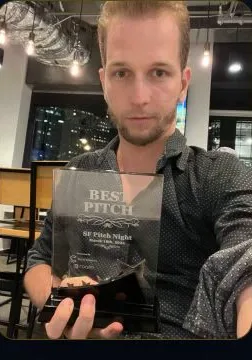 David Riha holding the Best Pitch award